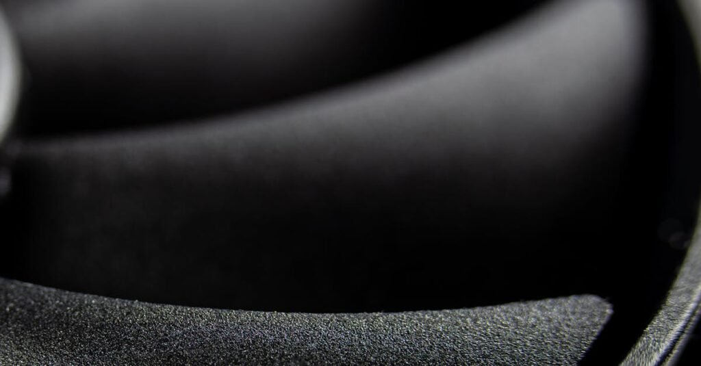 Detailed macro shot of a computer cooling fan showcasing its blades in grayscale tones.